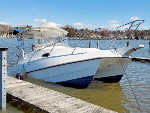 sinking white catamaran boat in boat slip