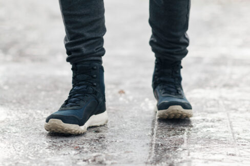 People slides on path. Icing on sidewalk, slippery ice-crusted ground.