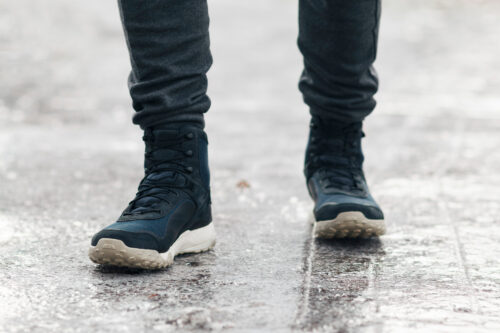 People slides on path. Icing on sidewalk, slippery ice-crusted ground.